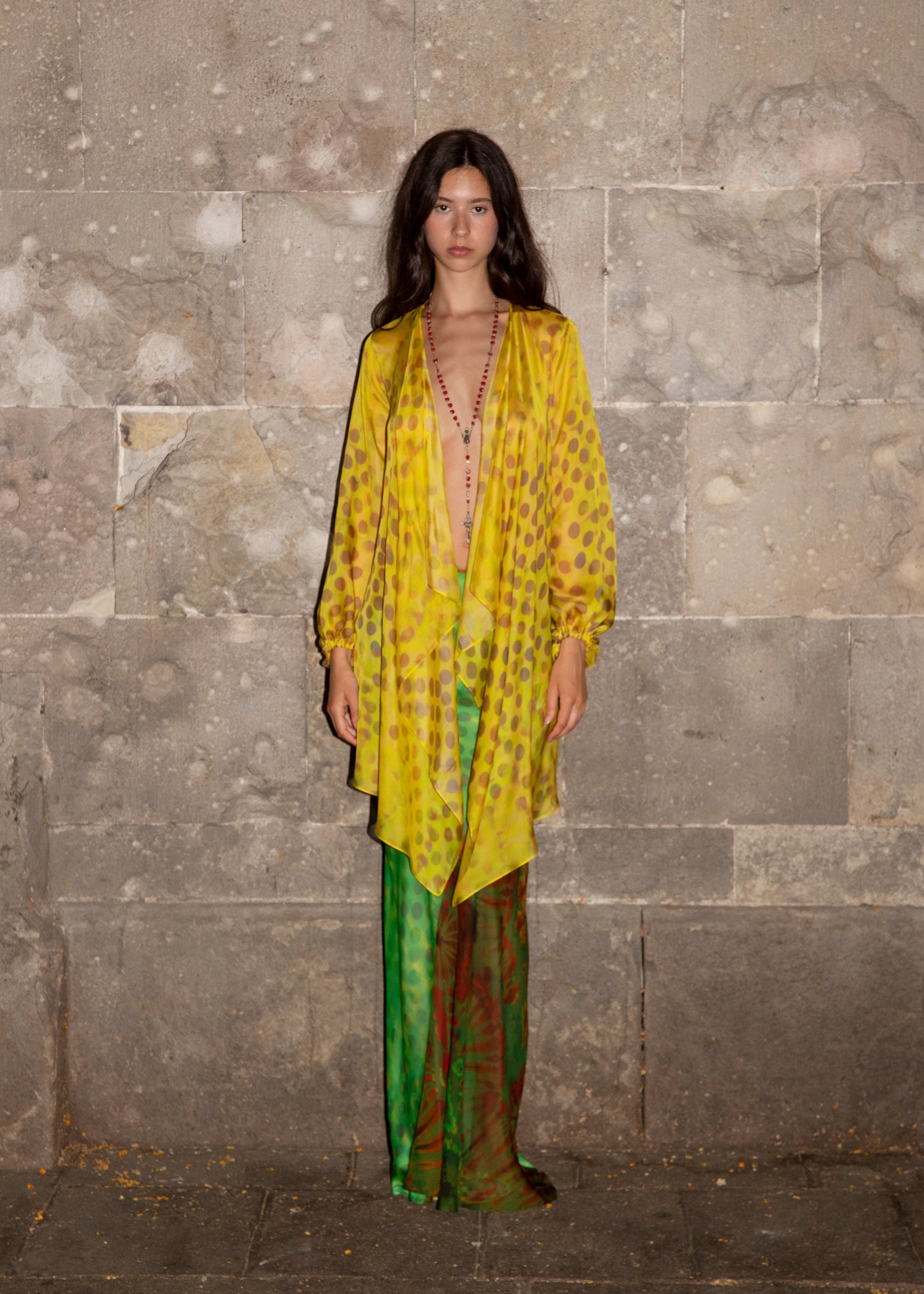 Woman wearing Exotica skirt in Nimphidia against a stone wall. 