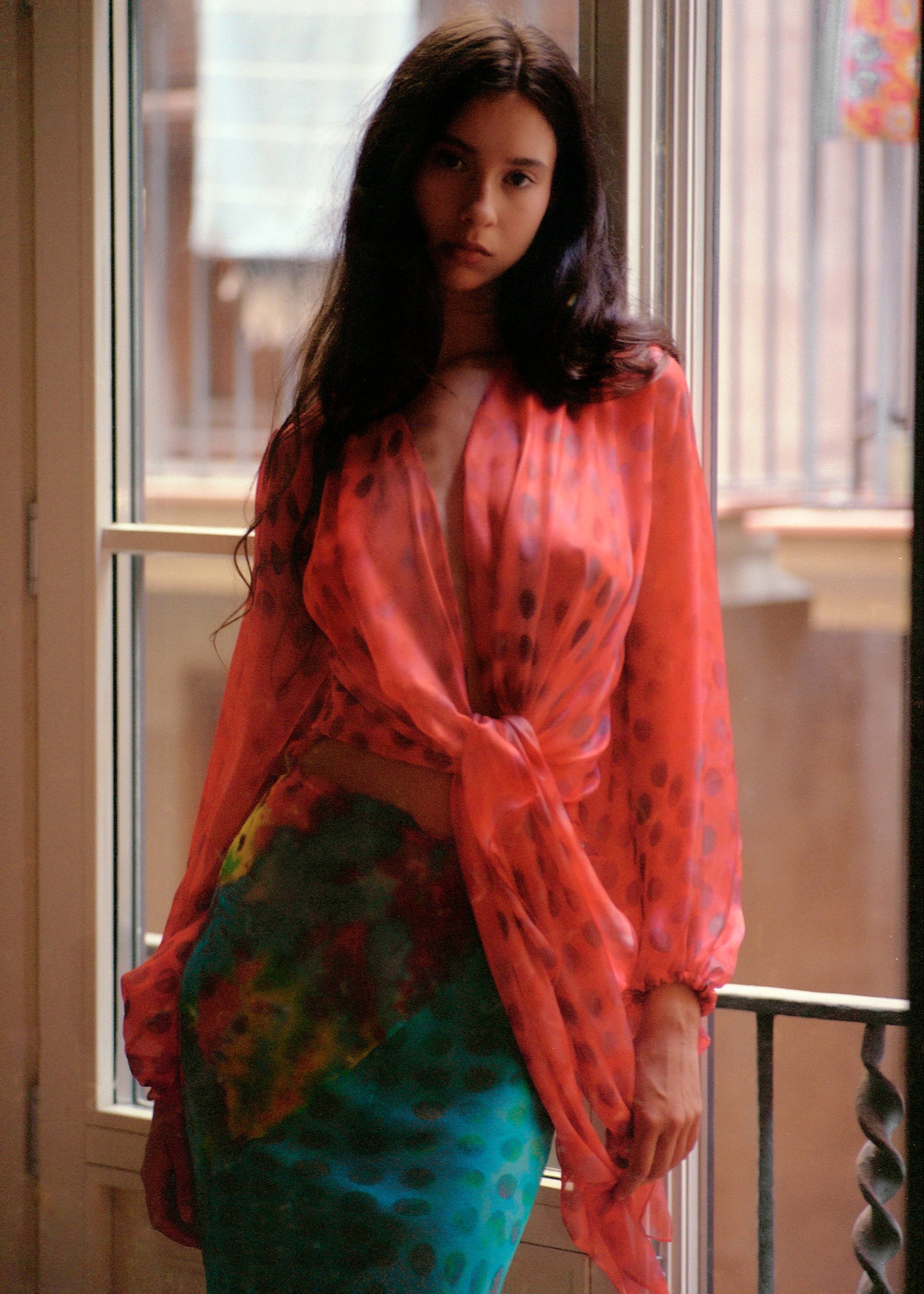 Woman wearing Electrica blouse in Cherry Sangria in an indoor setting.