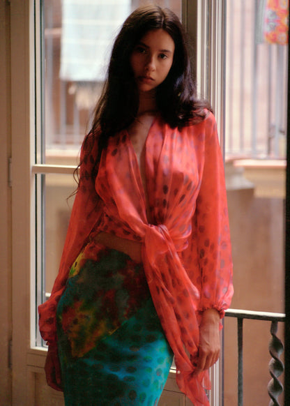 Woman wearing Electrica blouse in Cherry Sangria in an indoor setting.