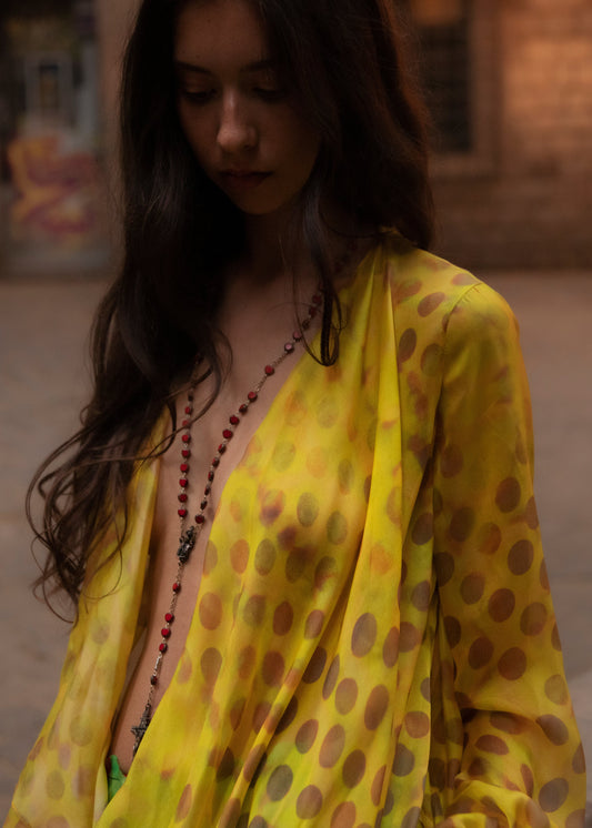 Woman wearing Electrica blouse in Honeybaby with a blurred background