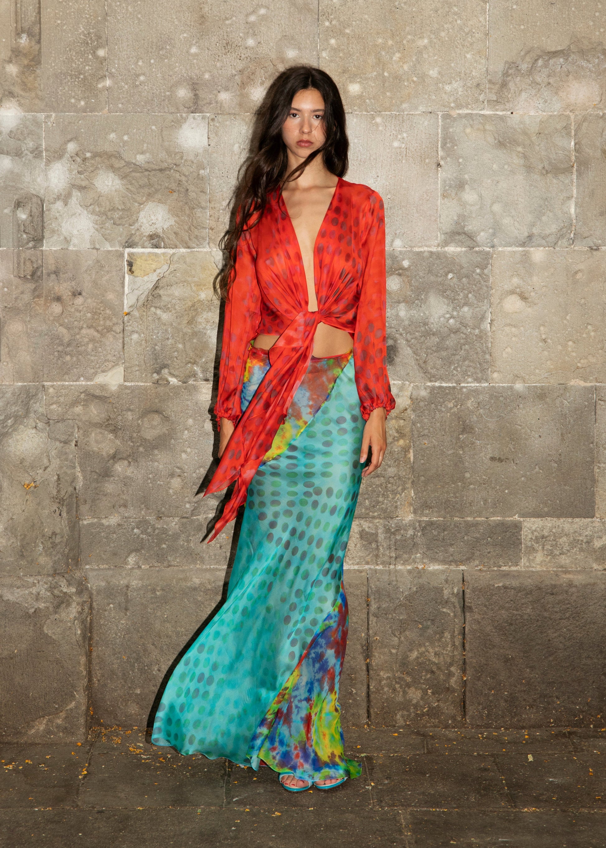 Woman wearing Exotica skirt in daydream against stone wall
