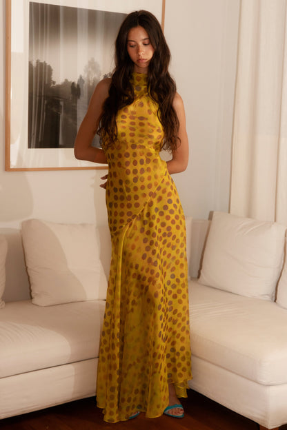 Woman in Romantica dress in Honeybaby standing in a living room.