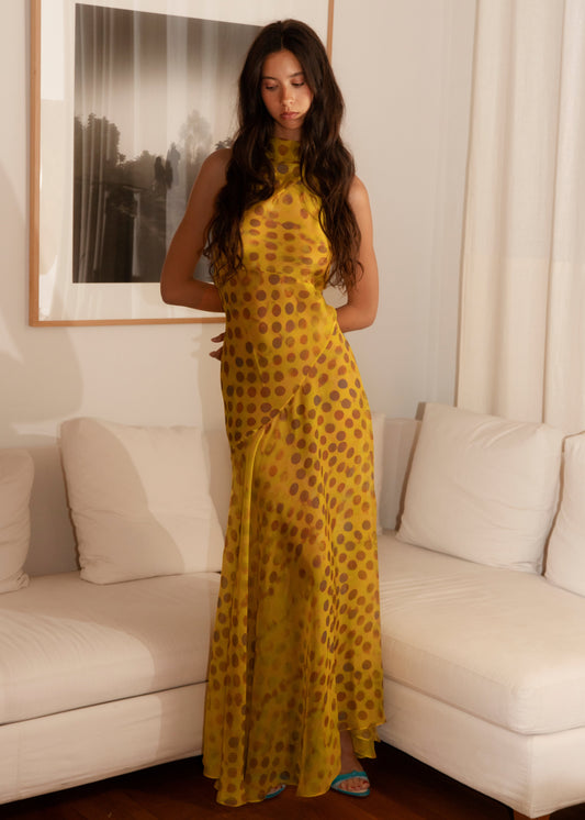 Woman in Romantica dress in Honeybaby standing in a living room.